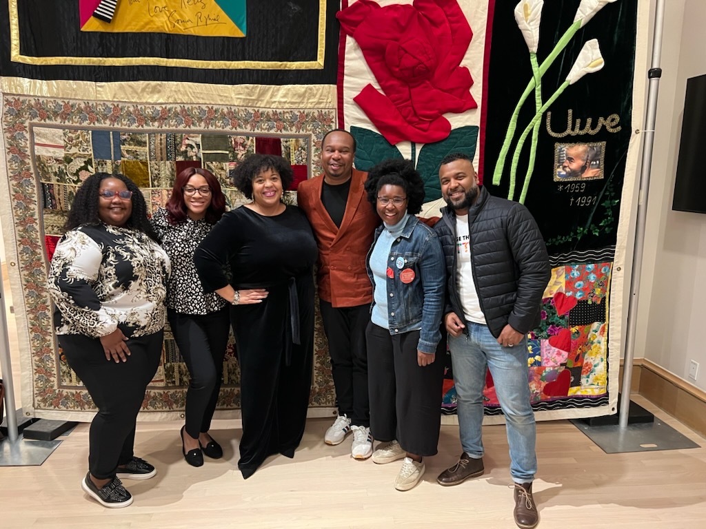 SAC team with Roy Wood Jr. in front of AIDS Quilt